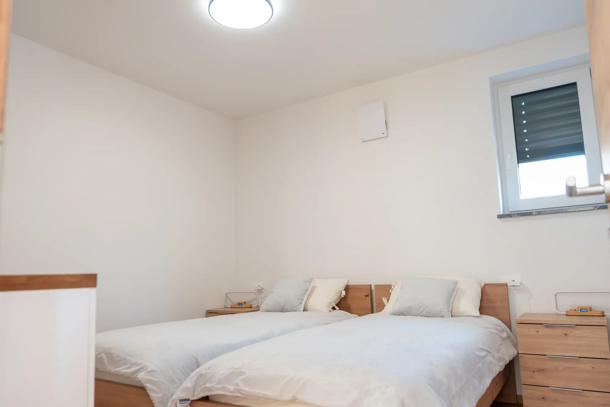The second bedroom — two single beds under crisp white linen